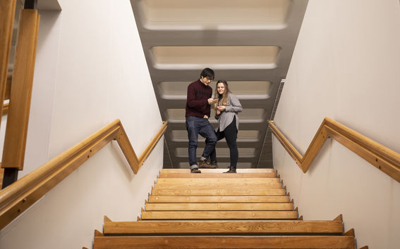 Kaksi opiskelijaa tulossa alas portaita.